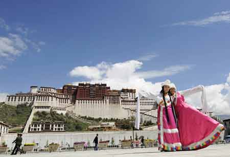 Two girls pose for photos at the square in front of the Potala Palace in Lhasa, capital of southwest China's Tibet Autonomous Region, on Aug. 6, 2008. Tibet had 96,000 tourist arrivals in June and the figure jumped to 350,000 for July, according to figures provided by the Tibet Autonomous Regional Tourism Bureau. The region is seeing quick recovery of local tourism industry over the two months from the impact of the March 14 violence. 