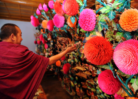 A monk checks the ghee flowers displayed at the Taer Monastery in Huangzhong County, northwest China's Qinghai Province, Feb. 8, 2009. An exhibition of ghee flowers that were hand-made by the monks of the Taer Monastery, was held to celebrate the Lantern Festival. In 2006, ghee flowers art was listed in China's intangible cultural heritage.